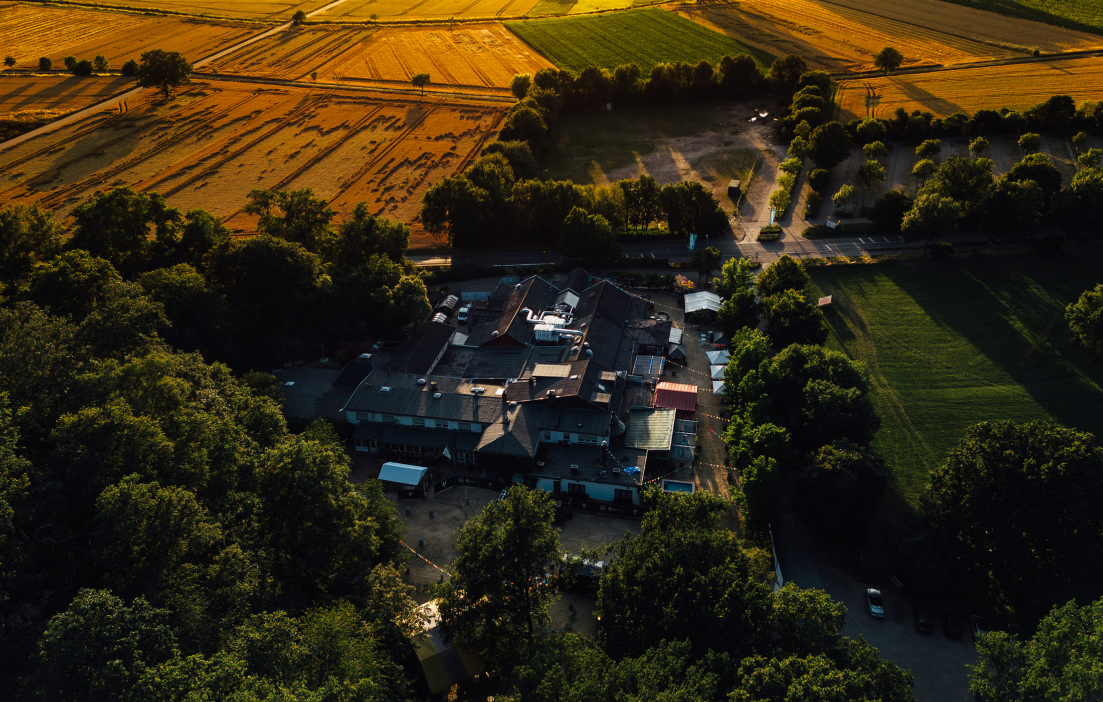 Luftaufnahme der Waldesruh in Himmerich im Abendlicht, umgeben von Wald und Feldern
